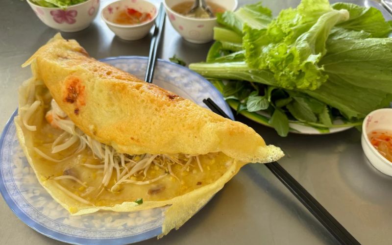Bánh xèo vàng giòn ăn kèm rau sống và nước chấm chua ngọt