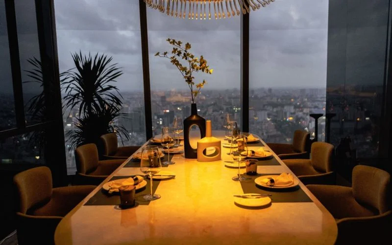 Không gian dùng bữa sang trọng tại SENS Dine & Wine với tầm nhìn toàn cảnh thành phố từ trên cao vào buổi tối