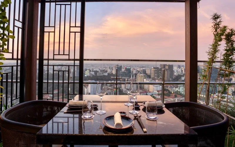 Không gian dùng bữa tại Lai Restaurant với tầm nhìn toàn cảnh skyline TPHCM từ trên cao vào thời điểm hoàng hôn
